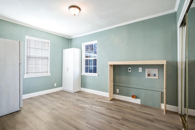 interior space featuring hardwood / wood-style floors, crown molding, a closet, and white refrigerator