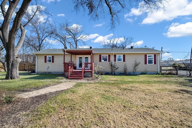 ranch-style home featuring a wooden deck and a front lawn