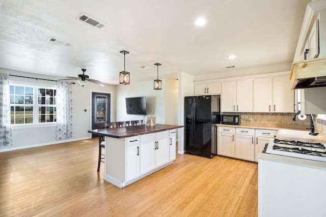 kitchen with white cabinetry, backsplash, pendant lighting, and black appliances