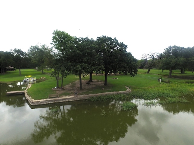 view of property's community with a lawn and a water view