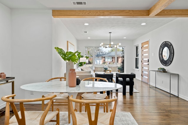 dining space featuring dark wood-type flooring, a chandelier, and beam ceiling