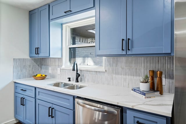 kitchen with blue cabinets, sink, light stone counters, stainless steel appliances, and decorative backsplash