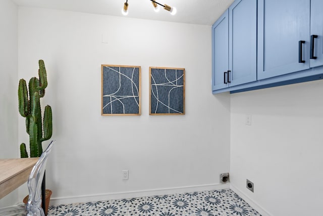 laundry area featuring cabinets, hookup for an electric dryer, and light tile patterned floors