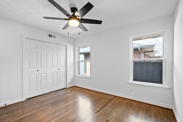 unfurnished bedroom featuring hardwood / wood-style flooring, ceiling fan, and a closet