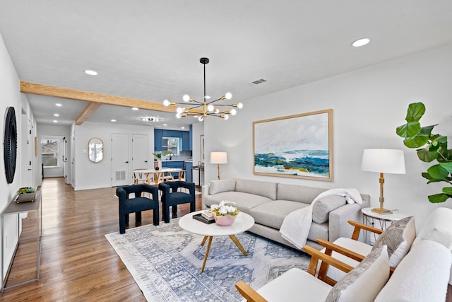 living room featuring an inviting chandelier, hardwood / wood-style flooring, and beamed ceiling