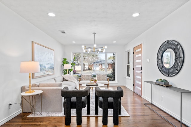 dining room with dark wood-type flooring and a notable chandelier