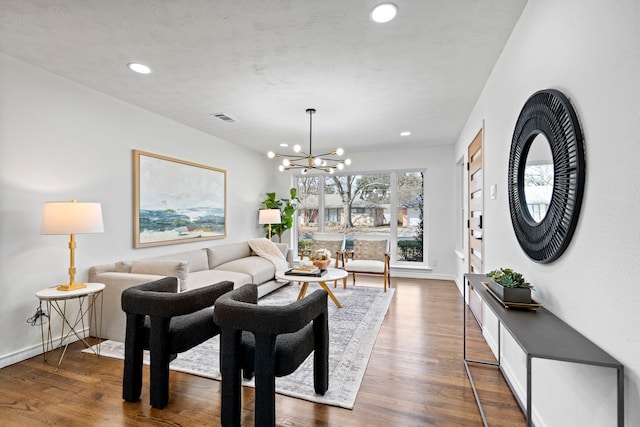 living room featuring an inviting chandelier and dark hardwood / wood-style flooring