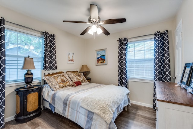 bedroom with dark wood-type flooring, ceiling fan, and multiple windows