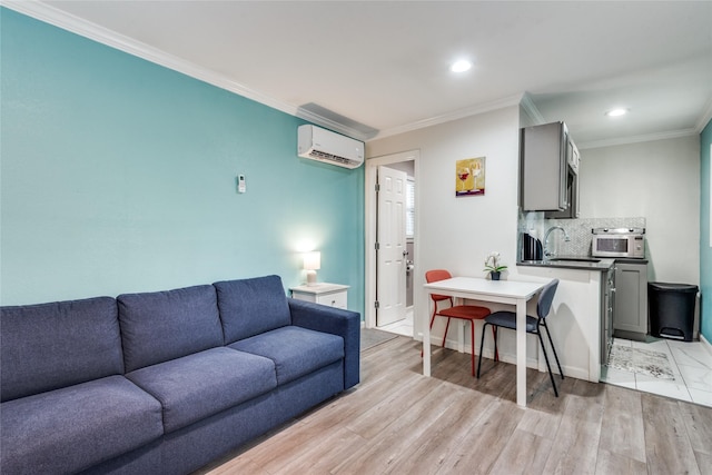 living room featuring sink, ornamental molding, a wall mounted AC, and light wood-type flooring