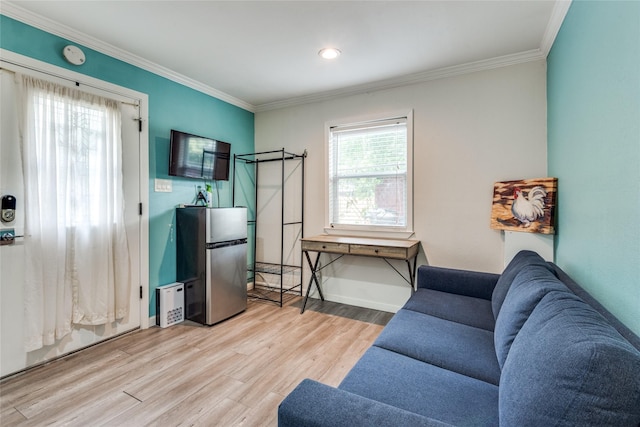 living room with crown molding, a wealth of natural light, and light wood-type flooring