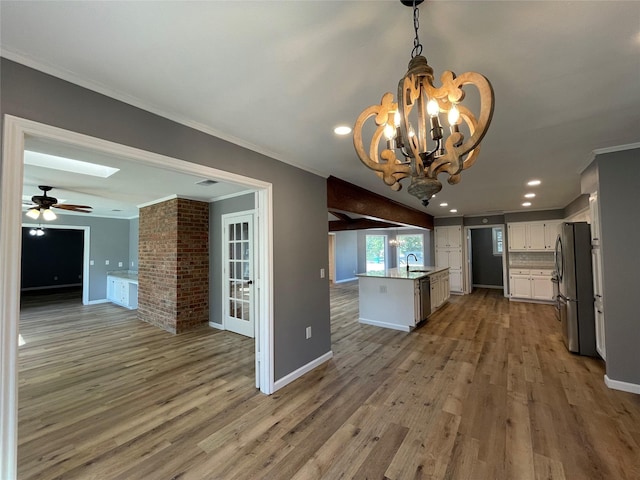 kitchen featuring sink, white cabinetry, decorative light fixtures, ornamental molding, and stainless steel appliances