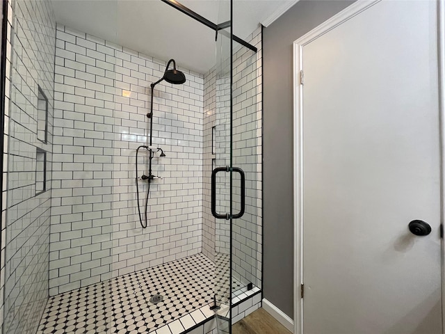 bathroom with ornamental molding and an enclosed shower