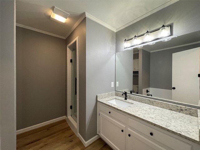 bathroom featuring hardwood / wood-style flooring, vanity, crown molding, and a shower with door