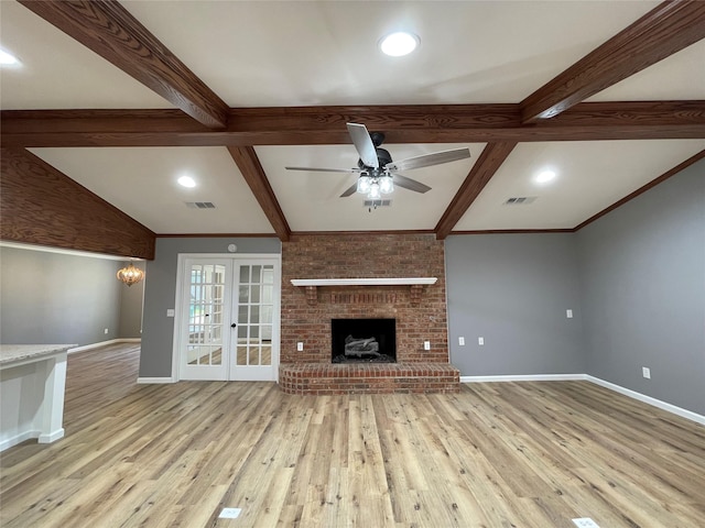 unfurnished living room featuring a fireplace, beamed ceiling, light hardwood / wood-style flooring, ceiling fan, and french doors