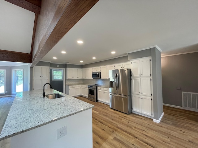 kitchen featuring sink, light hardwood / wood-style flooring, stainless steel appliances, light stone countertops, and white cabinets