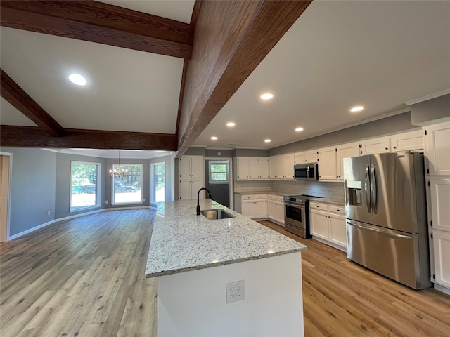 kitchen featuring appliances with stainless steel finishes, beam ceiling, and white cabinets