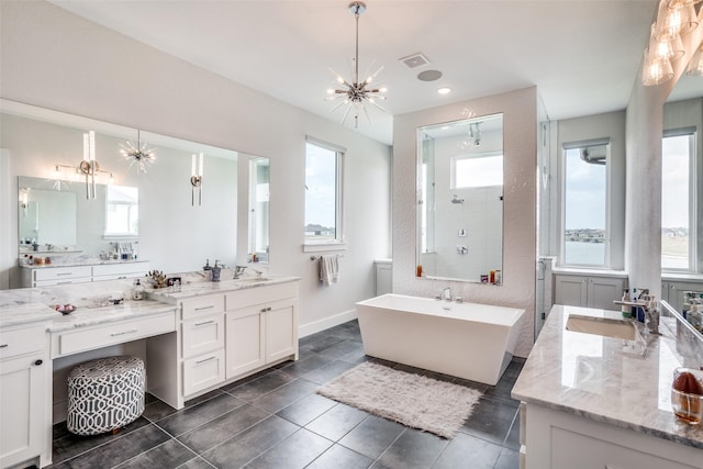 bathroom with an inviting chandelier, vanity, tile patterned flooring, and independent shower and bath