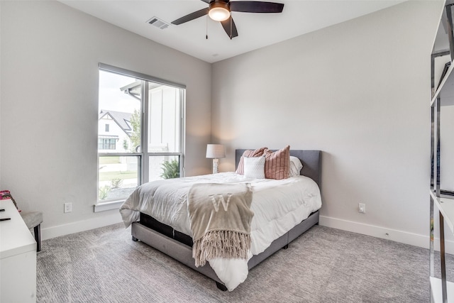 bedroom featuring multiple windows, light colored carpet, and ceiling fan