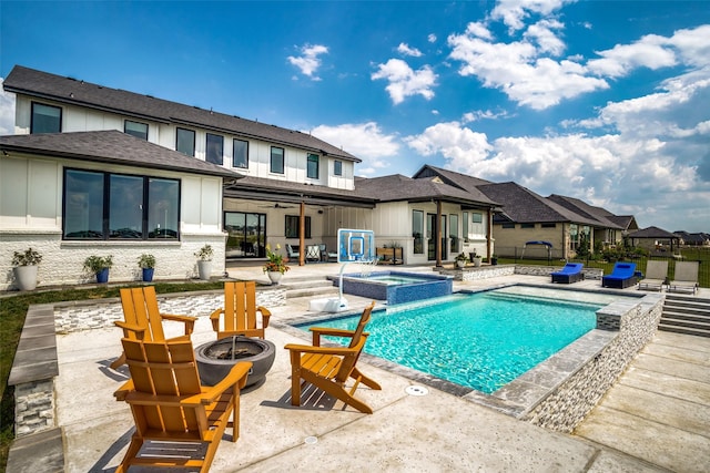 view of swimming pool with an in ground hot tub, a patio area, and a fire pit