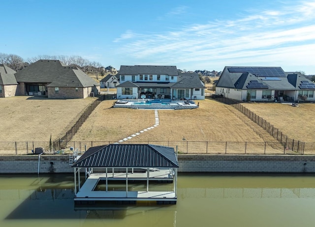 dock area featuring a fenced in pool, a water view, and a yard