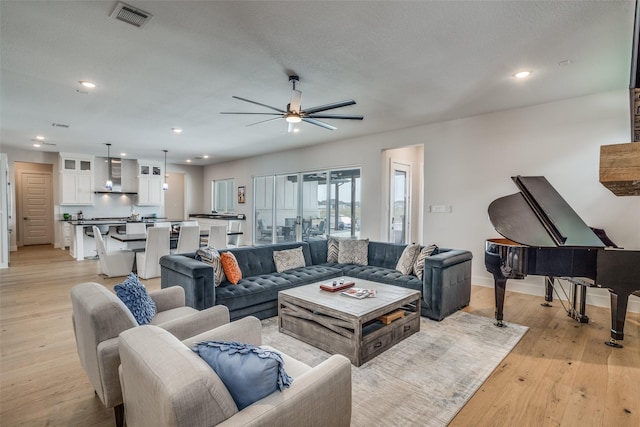 living room featuring ceiling fan and light hardwood / wood-style floors