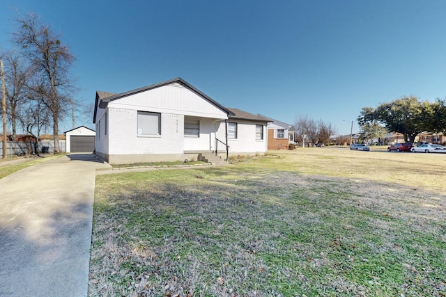 exterior space with a garage, an outdoor structure, and a lawn