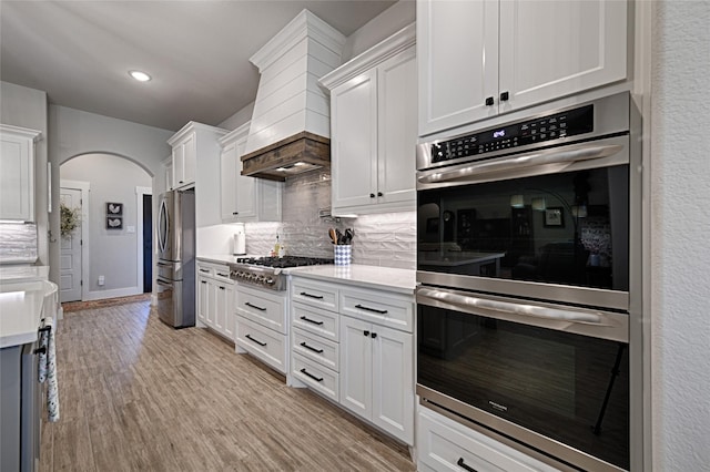 kitchen featuring backsplash, white cabinets, and appliances with stainless steel finishes