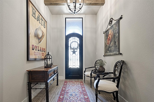 foyer entrance featuring beamed ceiling, a wealth of natural light, and a chandelier