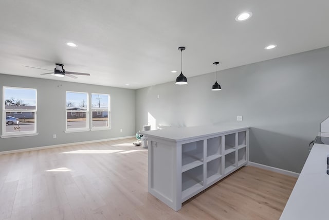 kitchen with ceiling fan, decorative light fixtures, light wood-type flooring, and kitchen peninsula