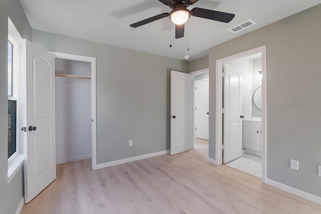 unfurnished bedroom with a closet, connected bathroom, ceiling fan, and light hardwood / wood-style floors