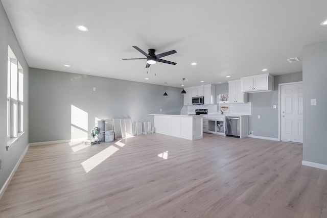 unfurnished living room featuring ceiling fan and light wood-type flooring