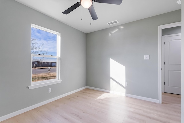 empty room featuring ceiling fan, plenty of natural light, and light wood-type flooring