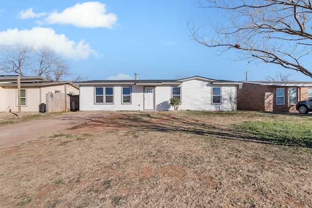 rear view of property with central AC unit and a lawn