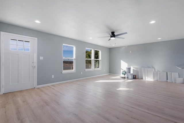 unfurnished living room featuring ceiling fan and light wood-type flooring