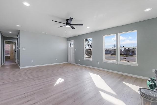 unfurnished living room featuring ceiling fan and light wood-type flooring