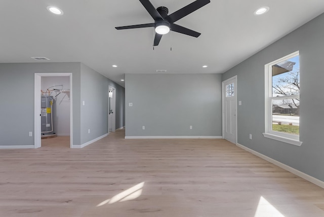 unfurnished living room with water heater, ceiling fan, and light wood-type flooring