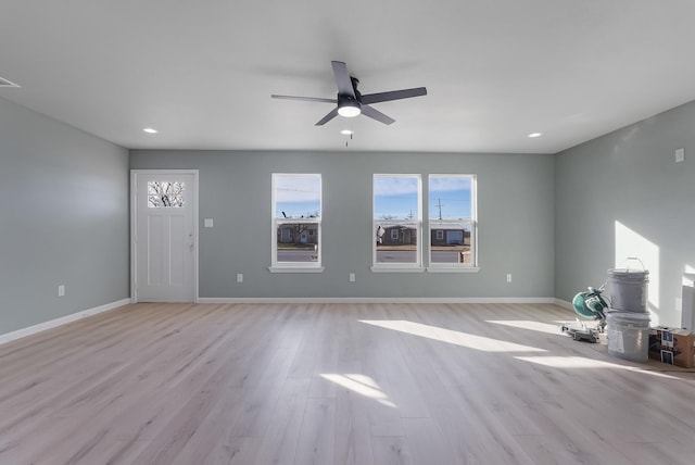 unfurnished living room featuring ceiling fan and light hardwood / wood-style flooring