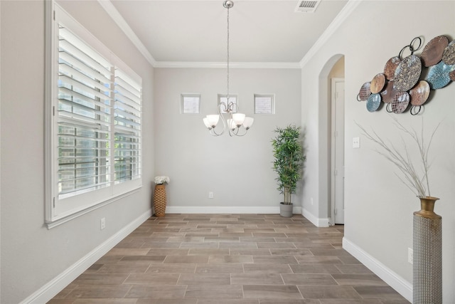 unfurnished dining area with an inviting chandelier, crown molding, and light hardwood / wood-style flooring