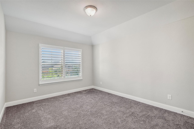 unfurnished room featuring vaulted ceiling and carpet floors