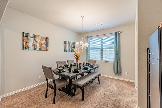 dining space featuring carpet flooring and a notable chandelier