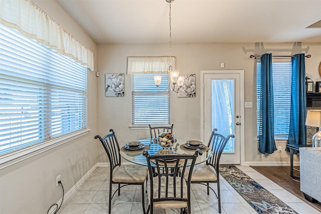 dining space featuring a healthy amount of sunlight, tile patterned floors, and an inviting chandelier