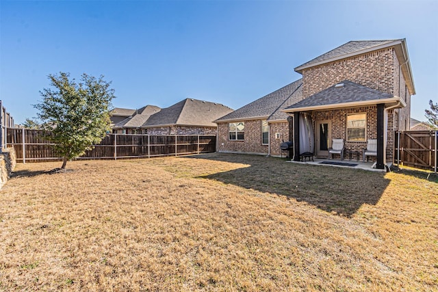 back of house featuring a yard and a patio area