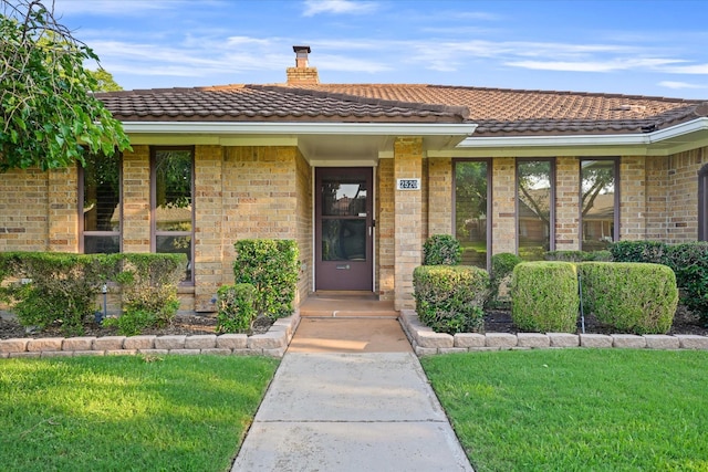 property entrance featuring a lawn