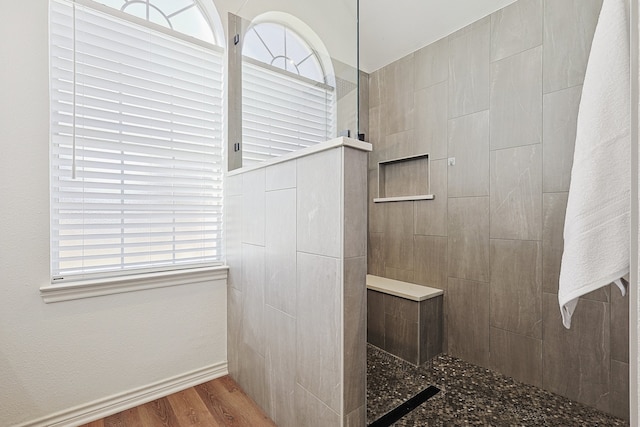 bathroom featuring baseboards, walk in shower, and wood finished floors