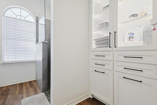 walk in closet with dark wood-type flooring