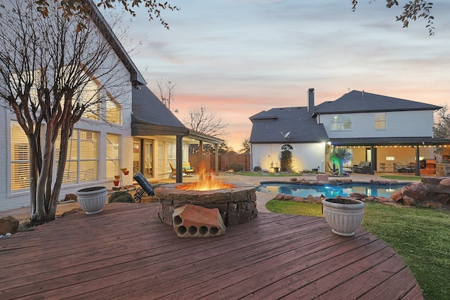 wooden deck with a fire pit and a fenced in pool