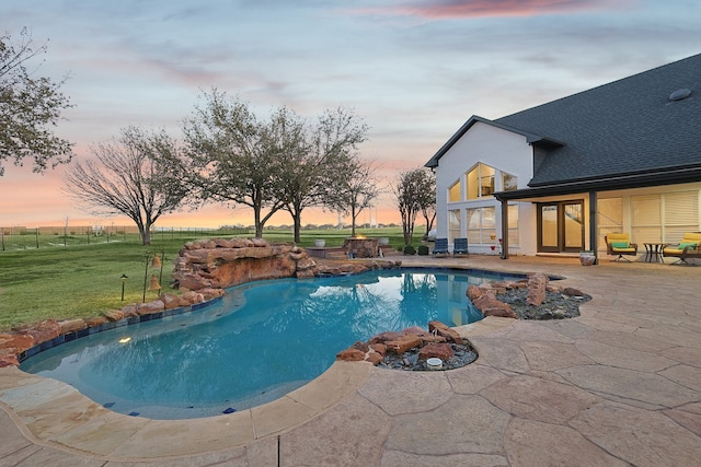 pool featuring a patio area and a lawn