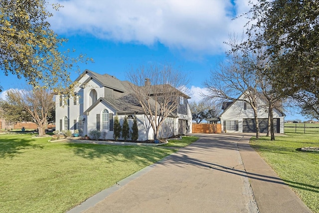 exterior space with a yard, a chimney, fence, and stucco siding