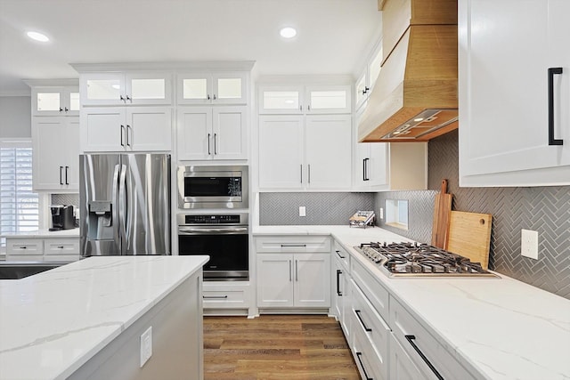 kitchen featuring premium range hood, appliances with stainless steel finishes, and white cabinetry