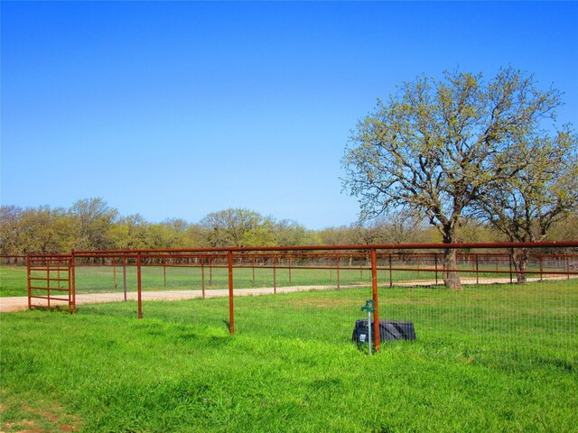 view of gate with a yard and a rural view